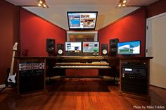 a recording studio with multiple monitors and keyboards