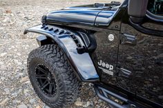 the jeep is parked on some rocks and has its door handle up to show off