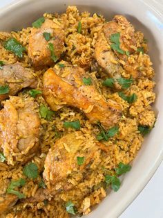 a white bowl filled with rice and meat covered in cilantro leaves on top