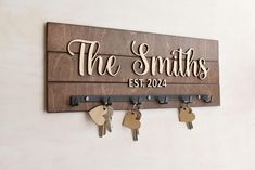 a wooden sign that says the smiths with keys hanging from it's hooks