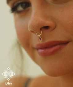 a close up of a woman with a nose ring on her nose and the word dia written below it