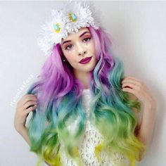 a woman with multi colored hair and flowers in her hair is posing for the camera