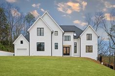 a large white house sitting on top of a lush green field