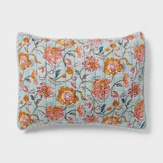 a blue pillow with orange and pink flowers on it