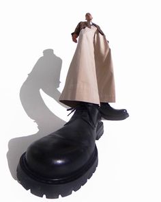 the shadow of a man's head and shoes on a white background with a black shoe