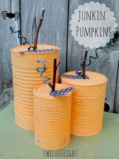 three orange tin cans with halloween decorations on them and the words junkin'pumpkins