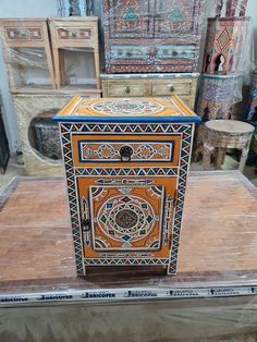 an orange and black box sitting on top of a wooden table next to other boxes