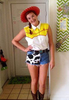 a woman in a short skirt and cowboy hat standing next to a door with her hands on her hips