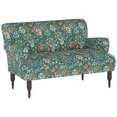 a green floral couch with wooden legs