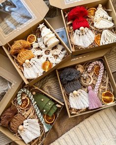 four boxes filled with assorted knitted items on top of a bed covered in blankets