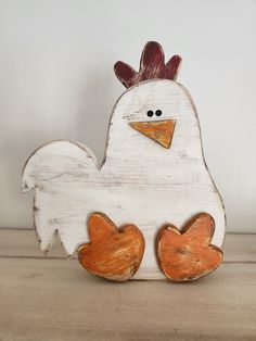 a wooden chicken with two hearts on it's feet