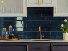 a kitchen with blue tiles and gold trim on the cabinet doors, counter tops and drawers