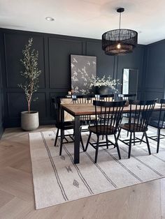 a dinning room table with chairs and a rug on the floor in front of it