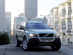 a silver volvo suv driving down a city street