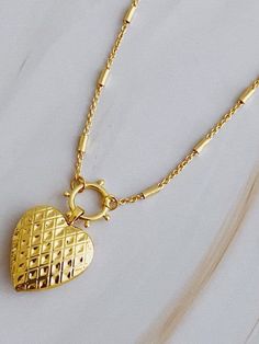 Add a touch of edge to your style with the Patterned Heart Open Locket Necklace. The intricate design pairs perfectly with the delicate heart locket, creating a one-of-a-kind accessory. Ideal for any occasion, the dainty chain adds a subtle touch. Color: Gold Made of: 18k gold plated brass, Lead and nickel-free Brand: Ellison and Young Includes: x1 Necklace Length: Approximately 16" with a 2" extender Elegant Heart Pendant Locket Necklace With Adjustable Chain, Elegant Heart Pendant Locket Necklace With Charms, Dainty Heart Charm Locket Necklace, Delicate Heart Pendant Locket Necklace, Heart-shaped Metal Necklace For Her, Gold Open Heart Necklace With Lobster Clasp, Wedding Necklace With Heart Pendant And Lobster Clasp, Elegant Double Heart Locket Charm Necklaces, Metal Heart Pendant Necklace As A Gift For Her