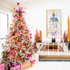 a brightly colored christmas tree in the corner of a living room with presents under it