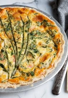 a pizza sitting on top of a metal pan covered in cheese and veggies