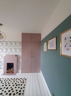 a room with blue walls and white flooring has a pink fire place in the fireplace