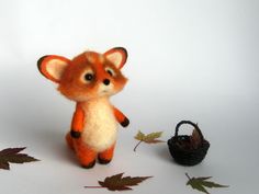 a small stuffed animal sitting next to a basket with leaves on the ground and a pine cone in front of it