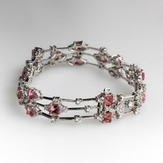 The fancy link three-row bracelet is accented with a total of twenty-one (21), prong set, square step cut natural pink tourmaline and one hundred fifty-five (155), prong set, round brilliant cut diamonds. The bracelet measures 12.5mm wide and an overall length of 7-1/2 inches. The bracelet is finished with a box clasp and fold-over safety. Luxury Tourmaline Jewelry With Prong Setting, Elegant Multi-stone Pink Sapphire Jewelry, Elegant Pink Sapphire Multi-stone Jewelry, Luxury Tourmaline Jewelry For Formal Occasions, Elegant Baguette Cut Tourmaline Jewelry, Elegant Baguette-cut Tourmaline Jewelry, Fine Jewelry With Baguette Cut Tourmaline, Fine Jewelry Tourmaline Baguette Cut, Elegant Pink Baguette Cut Jewelry