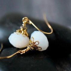 These simple yet elegant handmade white opal crystal earrings are created in a minimal style with a vintage twist to a classic look.   I combined pretty white alabaster opaque faceted glass crystals and layers of gold plated caps and beads.   Dangle beautifully from gold plated hook ear wires.   Perfect anytime!  Great to wear for the office, or everyday.   Pretty boho bridal earrings or other wedding party jewelry.   These dangle earrings go with everything and will make a thoughtful handmade gift for the special person in your life. ♛  Earrings Length:  approx. 1 1/4" inches long  ♛  Earrings Width :  approx. 1/2" inches wide ♛  Crystal Glass Rondelle :  12x8mm // 1/2" wide Select your favorite ear wires from the drop down menu [see ear wires examples in last photo]. Ready to ship, thoug Delicate White Crystal Earrings For Gift, Elegant Wedding Moonstone Earrings, Delicate White Dangle Crystal Earrings, Elegant Moonstone Dangle Crystal Earrings, Elegant Gold Crystal Earrings With Moonstone, Adjustable White Crystal Earrings For Gift, Delicate Moonstone Earrings For Wedding, Delicate White Crystal Earrings, Elegant White Moonstone Crystal Earrings