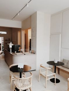 the interior of a restaurant with tables and chairs in front of an open kitchen area