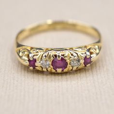 Antique 18k gold ring set with two old cut diamonds and three natural rubies. The gallery of the ring has a beautiful scrolling design. Hallmarked for Birmingham 1908. Era: Hallmarked for 1908 Markings: English hallmarks for 18k Birmingham 1908, C.L.M. (Maker's Mark) Materials: 18k gold, Diamonds (approx .10 ctw), Natural Rubies (2.14mm x 2) (3.04 x 1) Weight: 2.9 grams Ring Size: 8 1/4 (Comes with one free resizing by our jeweler) Condition: Excellent antique condition with minor surface wear from age  Shipping is free in the United States Follow us on Instagram @LUXXORVintage Antique Ruby Ring, Antique Gold Rings, Ruby And Diamond Ring, 18k Gold Ring, Ruby Jewelry, Jewelry Lookbook, Antique Engagement Rings, Pretty Rings, Maker's Mark