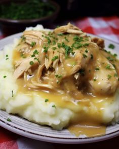 a white plate topped with mashed potatoes covered in gravy