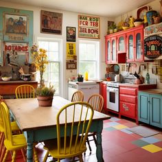 a kitchen with red cabinets, yellow chairs and a table in the middle of it