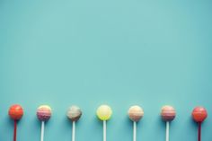 colorful lollipops lined up in a row on blue background - stock photo - images