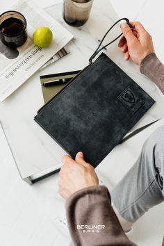 a person sitting at a table with a black bag on it's lap top