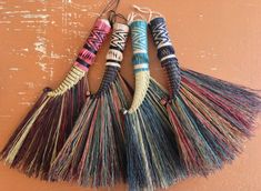 three different colored tassels hanging on a wall