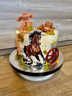 a birthday cake with a horse on it and the number 3 painted on top is sitting on a plate