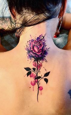 the back of a woman's neck with a rose tattoo on it