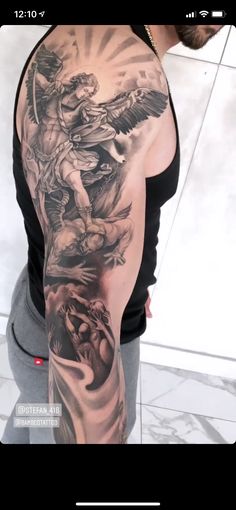 a man's arm with an angel and demon tattoo on the back of it