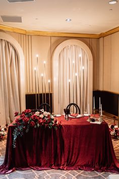 the table is set with red cloths and flowers