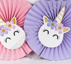 two paper fans with unicorn faces on them