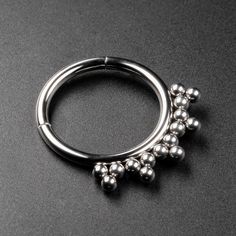 Type: Septum Clicker Ring Material: Implant Grade Titanium (ASTM F-136) Gauge Size: 1.2mm Internal Diameter: 8mm - 10mm Design: Triple Dot  We stock an awesome range of septum clickers here at SIBJ. Here we have an amazing Triple Dot design that looks stunning and suits all styles.  Our septum rings are incredibly easy to insert, simply pop the hinged segment open, insert and close with a satisfying snap! ASTM F-136 titanium is the ultimate material for new and healed piercings, guaranteeing no reactions or irritation.  - High mirror polish.  - Simple insertion with the hinged segment opening.  - Click back into place for that seamless ring look. ---------------------------------------- Shipping All orders are shipped from the UK and leave our studio the same day if the order is placed bef Hypoallergenic Silver Metal Septum Ring, Silver Hypoallergenic Metal Septum Ring, Septum Nose Rings, Septum Nose, Septum Rings, Piercing Septum, Bubble Ring, Septum Clicker, Septum Piercing