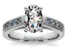 a diamond engagement ring with channeled diamonds on the band and side stones in 18k white gold