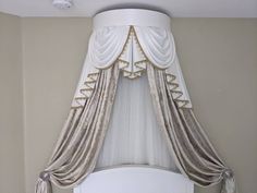 a white bed topped with a canopy over it's headboard and curtains hanging from the ceiling