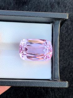 an oval shaped pink diamond in a box