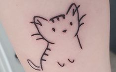 a small cat tattoo on the arm