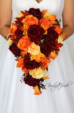 a bridal holding a bouquet of orange and red flowers on her wedding day,