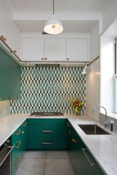 an image of a kitchen with green cabinets and white counter tops on the left side