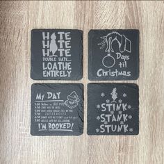 four black slate coasters with white writing on them