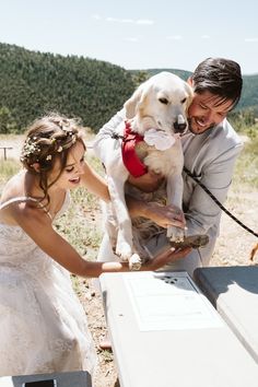 a man and woman holding a dog in their arms