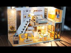 a doll house is shown with furniture and lights on the inside, as well as a staircase leading up to the second floor