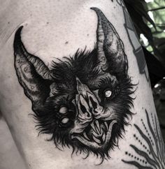 a black and white image of a demon with horns on his head, done by tattoo artist