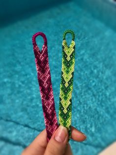 two small knitted items in the shape of umbrellas next to a swimming pool