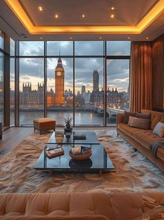 a living room filled with furniture and a large window overlooking the city at night time